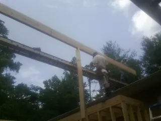 Carpenter setting a ridge beam over a new addition frame — Ice Dam Removal by Roofing Brothers in Colorado Springs