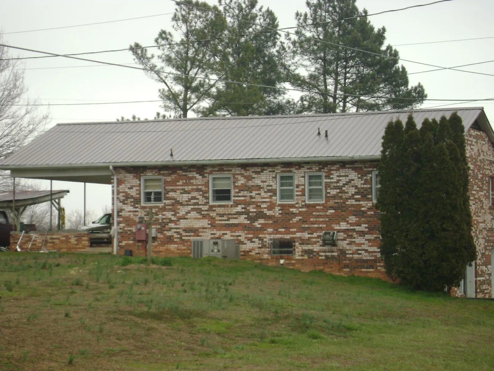 Gray metal roof on a brick split level home with a carport in Colorado Springs