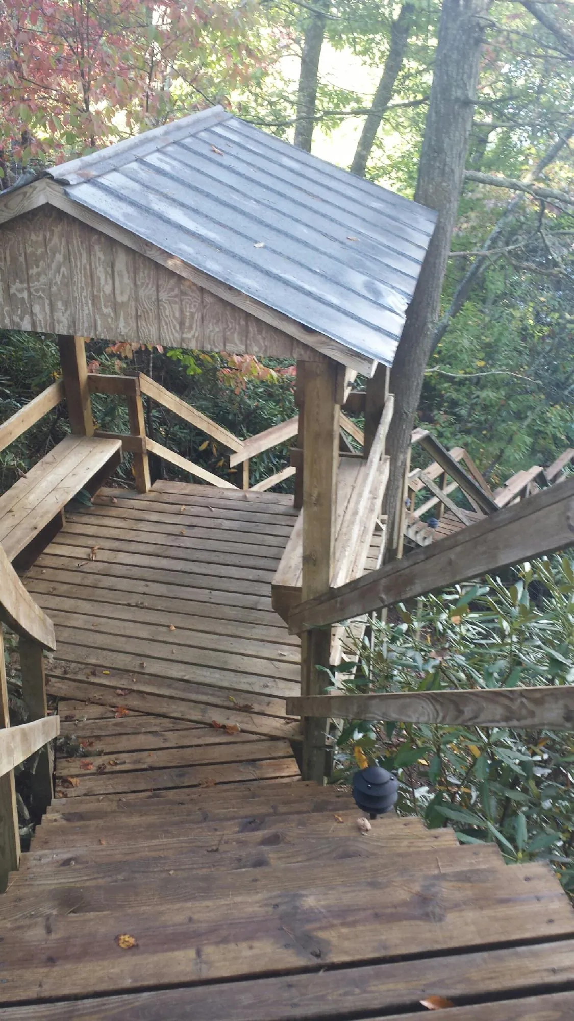 Metal roofed shelter over wooden steps on a wooded walkway — Skylight Repair & Installation work by our crew in Colorado Springs