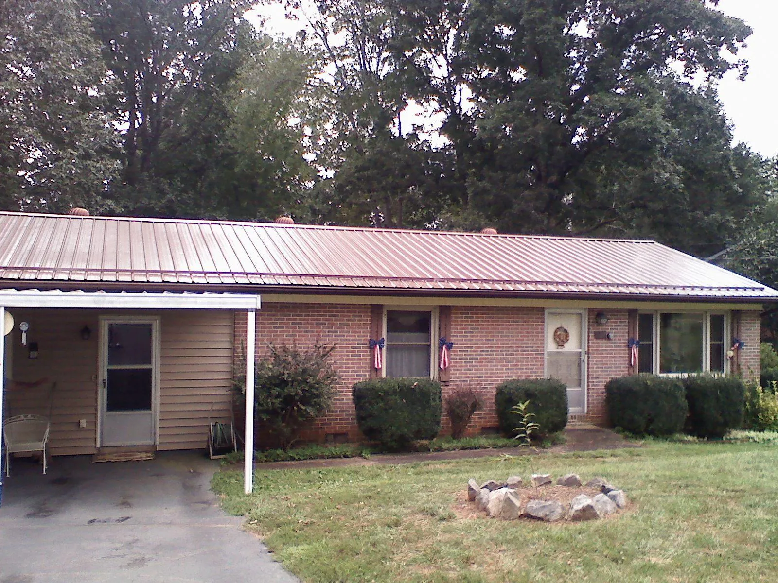 Bronze metal roof and carport on a brick ranch home — Roof Repair work by our crew in Colorado Springs
